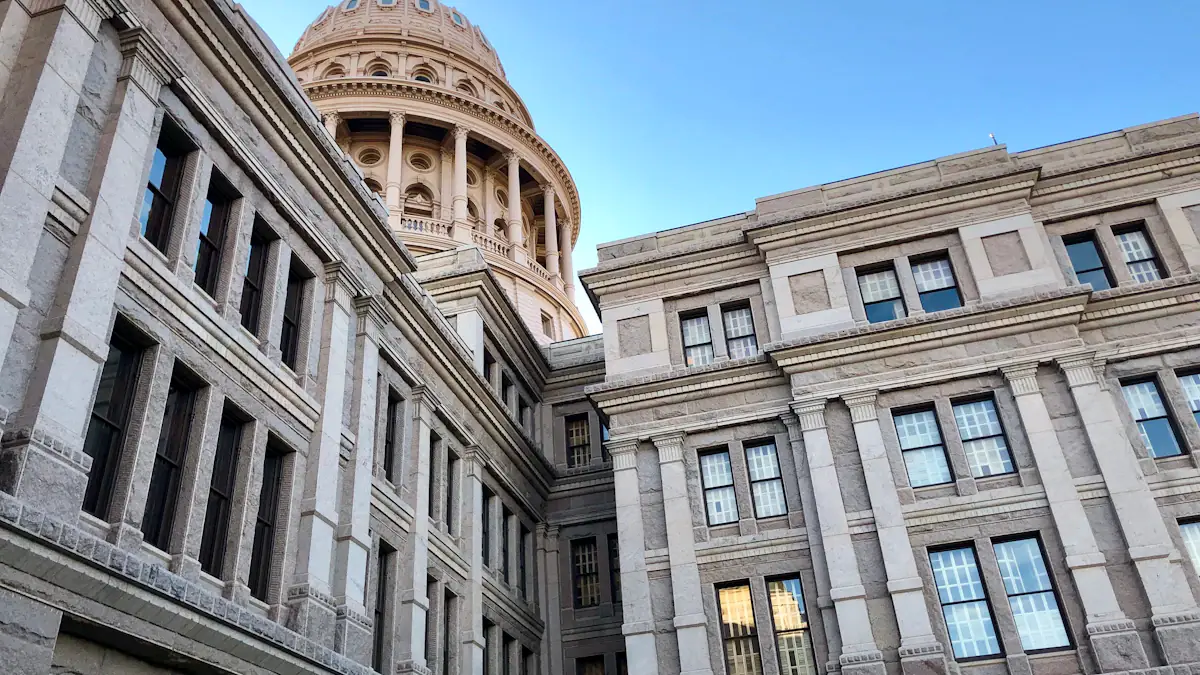 Stone government building with columns and a domed civic landmark.